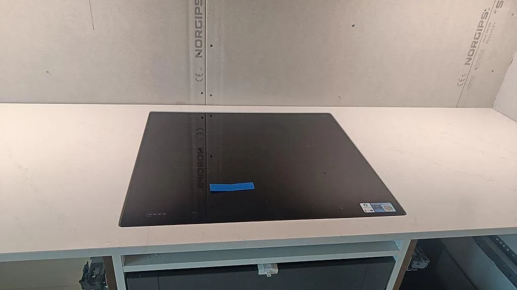 Induktionshäll i en poleret Silestone Eternal Statuario Bordplade med lys marmorkänsla i ett køkken i Varberg.