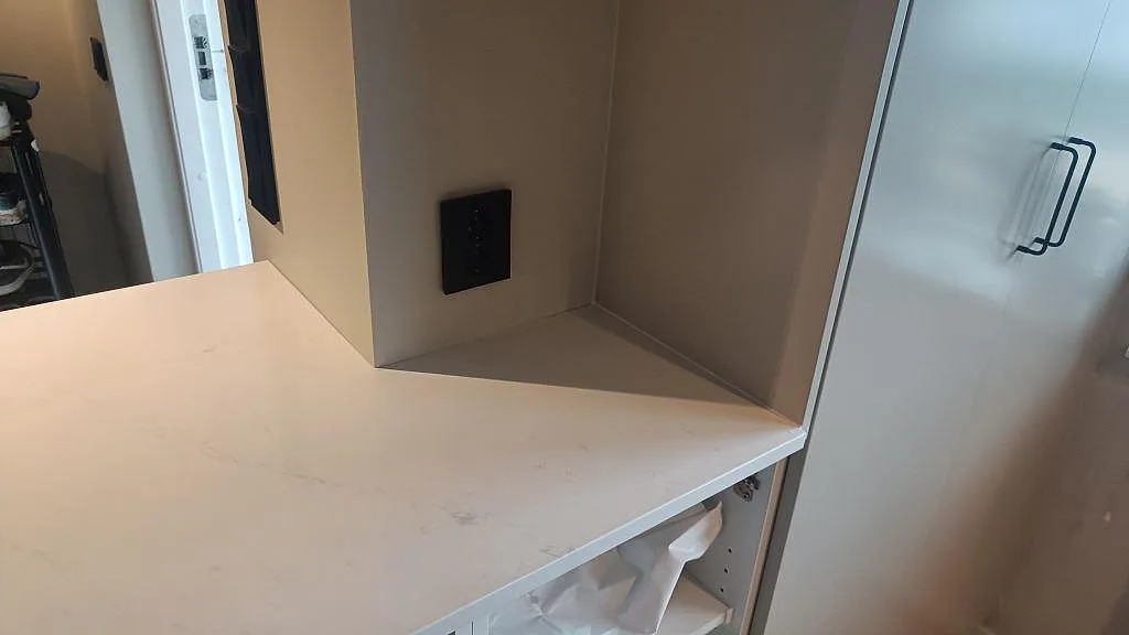 Sidovy af lys Silestone Eternal Statuario Bordplade vid högskåp og väggnisch i ett køkken i Varberg.