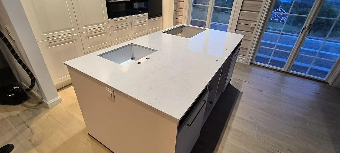 Køkkenbordplade i hvid Silestone Lagoon kvartskomposit, poleret, med underlimmad vask på en køkkenø i Siljansnäs.
