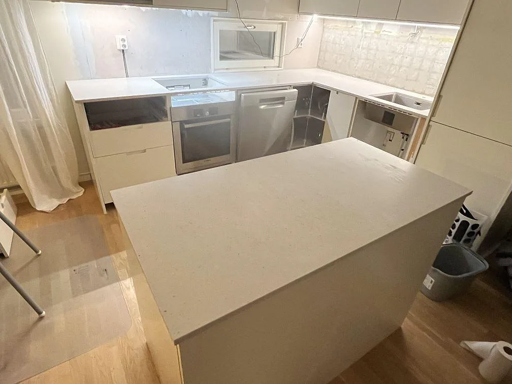 Køkkenbordplade i lys Silestone Lime Delight, mat Mocka-finish, monteret i ett U-format køkken under montering i Årsta.