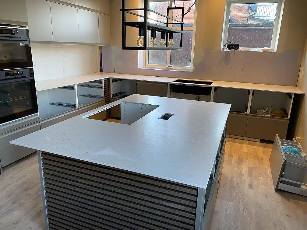 Køkkenbordplade og køkkenø i lys Silestone Lime Delight, 12 mm Mocka, med väggbänkar og öppet köksutrymme i Anderslöv.