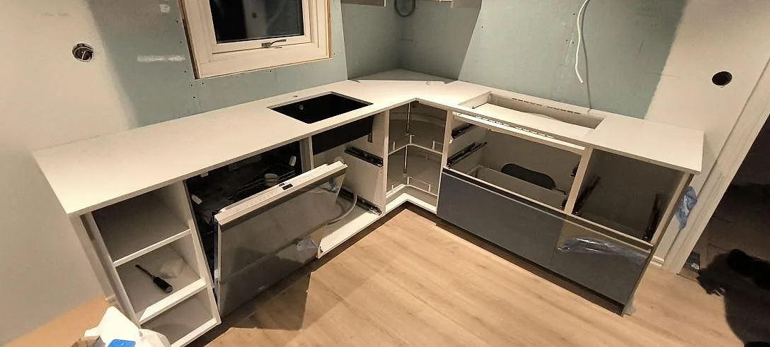 L-formad køkkenbordplade i lys Silestone Lime Delight, mat Mocka-finish, med synliga udskæring i ett køkken under montering i Borlänge.