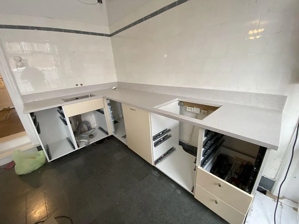 Køkkenbordplade i Silestone Lime Delight, mat kvartskomposit, monteret i vinkel med stænkplade, vask og hällöppning i ett køkken i Malmö.