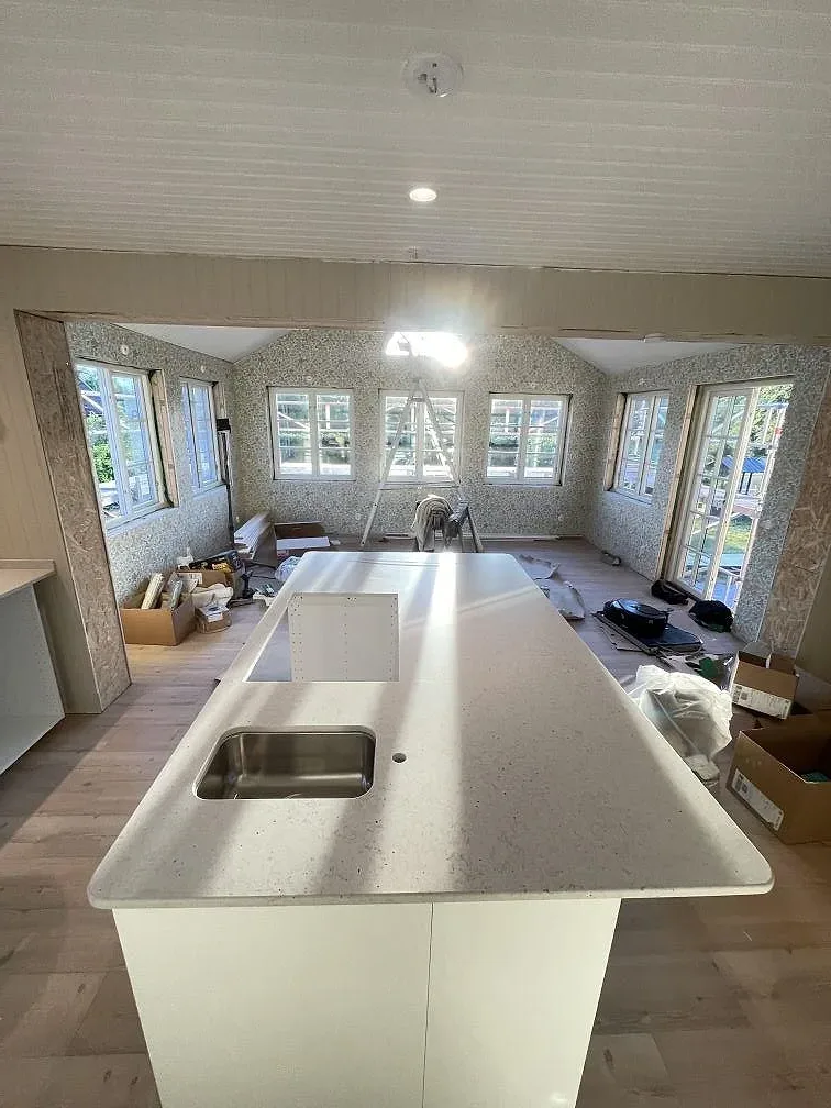 Køkkenbordplade og køkkenø i gräddvit Silestone Lime Delight, mat Mocka-finish, med underlimmad rostfri vask, i ett køkken under montering i Mörrum.