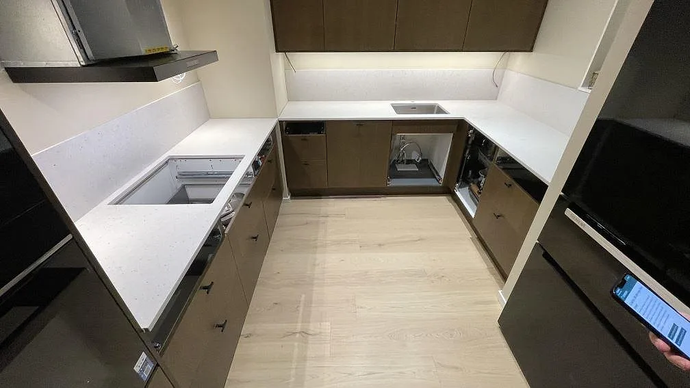 Køkkenbordplade i lys Silestone Lime Delight, mat Mocka, med stænkplade i ett U-format køkken i Växjö.