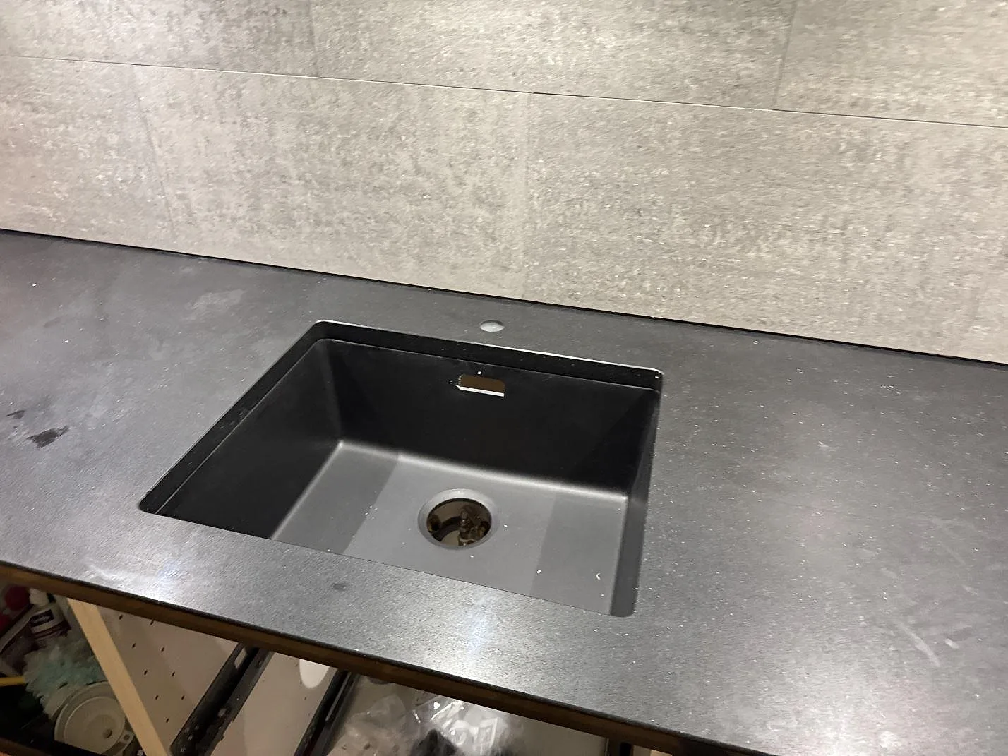Køkkenbordplade i mørk Silestone Night Tebas, poleret, med underlimmad mørk komposithon i ett køkken i Trelleborg.