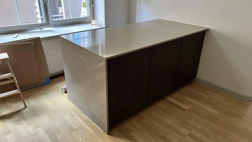 Køkkenbordplade i Silestone Night Tebas, mat kvartskomposit i Mocka, monteret på køkkenø med neddragen stensida i Tumba.