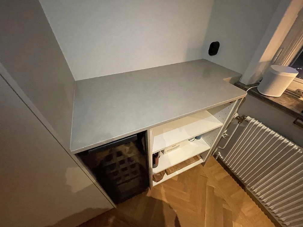 Køkkenbordplade i ljusgrå, betongliknande Silestone Poblenou i mat Mocka-finish, 20 mm, monteret over en køkkenbordplade med vinkyl under monteringen i ett køkken i Bromma.