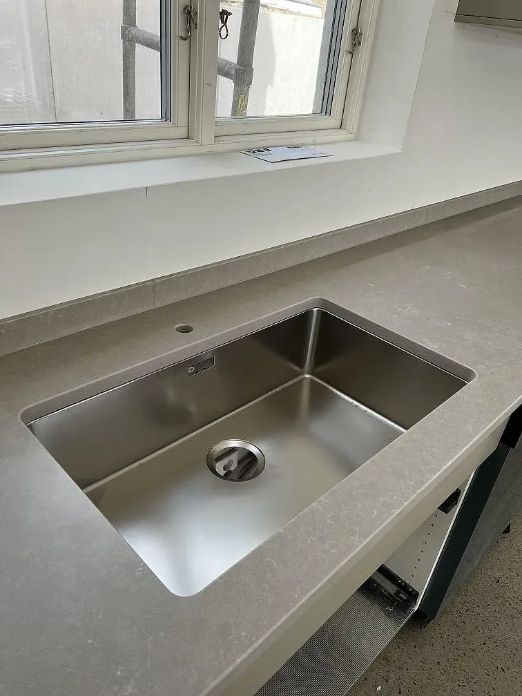 Køkkenbordplade i beige Silestone Poblenou med mat overflade og underlimmad rostfri vask i ett køkken under montering i Glumslöv.
