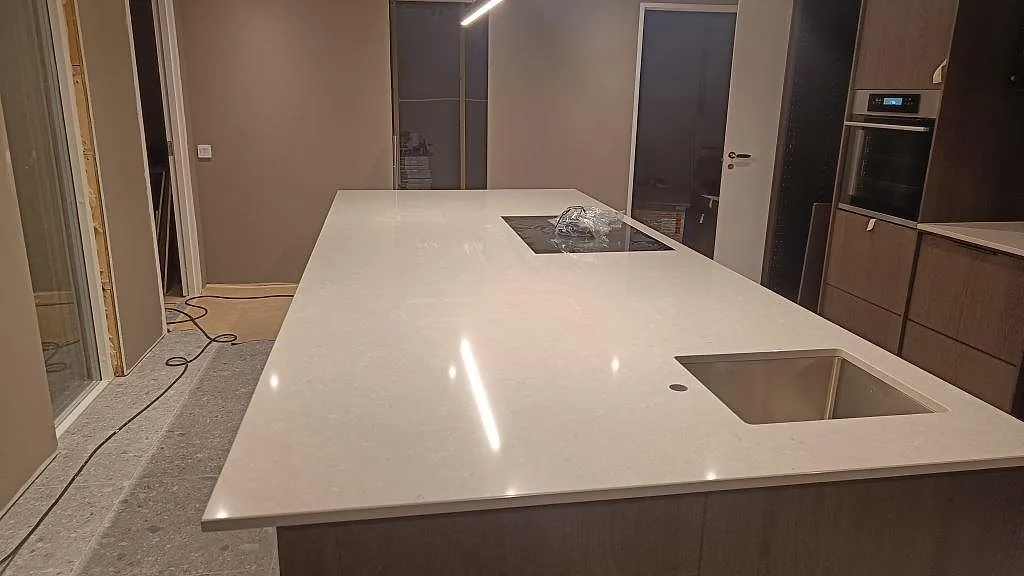 Køkkenø med Bordplade i lys Silestone Royal Reef, poleret kvartskomposit, underlimmad rostfri vask og hällöppning i Bjärred.