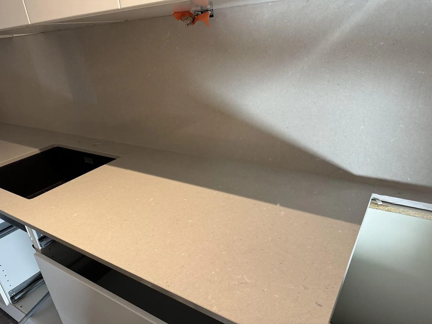 Køkkenbordplade i poleret Silestone Royal Reef, kvartskomposit, med sort vask og matchande vægbeklædning i ett køkken i Malmö.