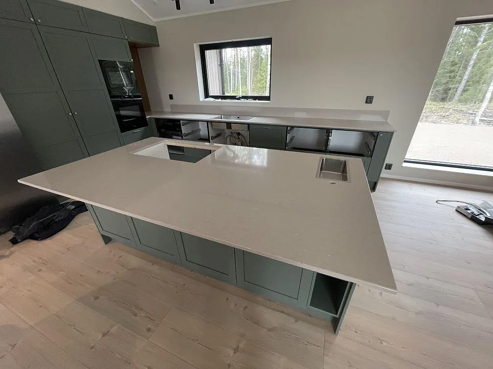 Køkkenbordplade i poleret Silestone Royal Reef, lys kvartskomposit, med stor køkkenø, hällzon og vask i Ransta.