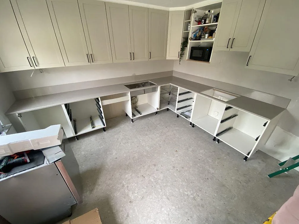 Køkkenbordplade i beige Silestone Royal Reef, poleret kvartskomposit, monteret i L-form längs ett køkken under montering i Trelleborg.