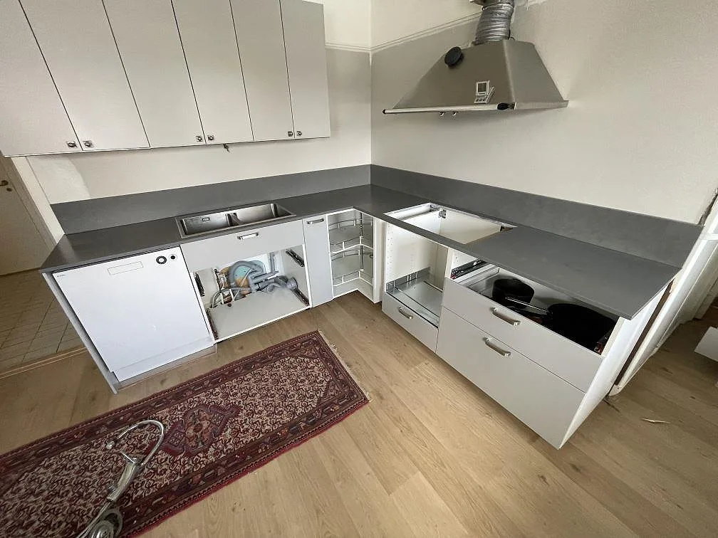 Køkkenbordplade i grå Silestone Seaport-komposit, mat Mocka, med vask og hällzon i ett L-format køkken i Karlstad.