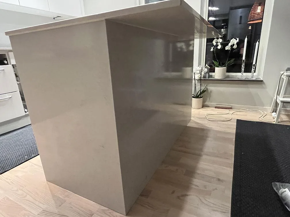 Poleret køkkenbordplade i hvid Silestone Snowy Ibiza, kvartskomposit, med vattenfallssida på en køkkenø eller halvö i Bålsta.