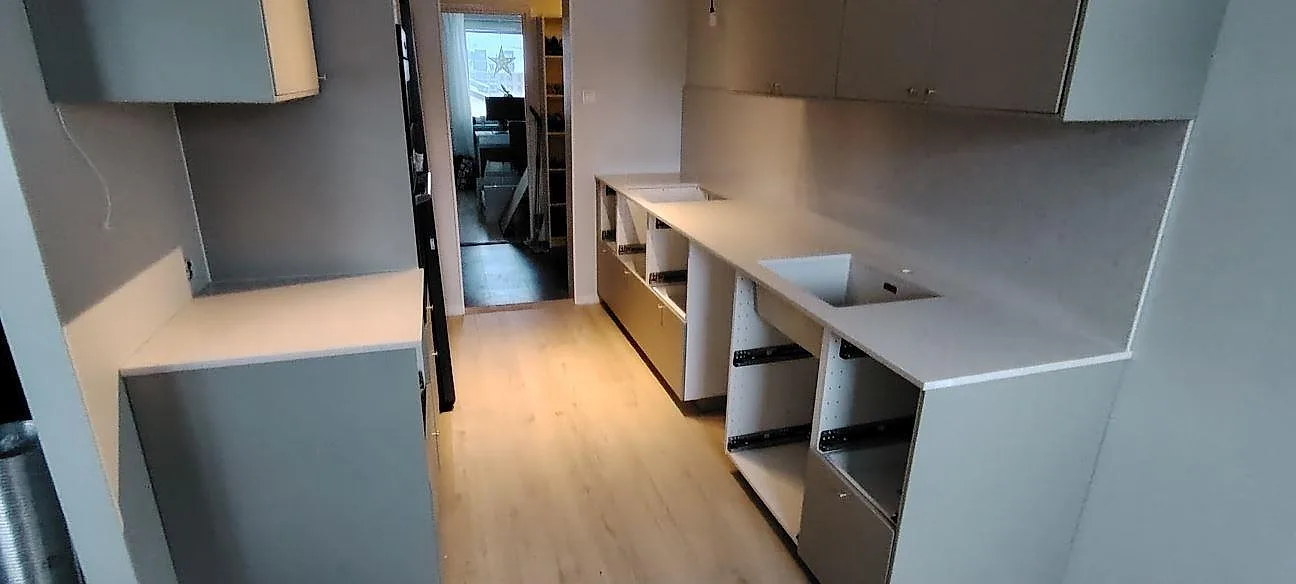Poleret køkkenbordplade i hvid Silestone Snowy Ibiza komposit med synlig urtagning og öppna köksstommar under montering i Knivsta.