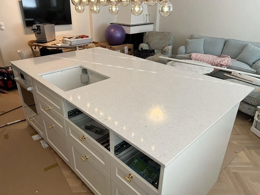 Køkkenbordplade i poleret hvid Silestone Snowy Ibiza, kvartskomposit, med förberedda udskæring i ett køkken i Lidingö.