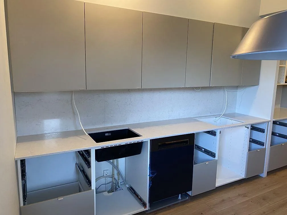 Køkkenbordplade i poleret Silestone Snowy Ibiza, kvartskomposit, med matchande stænkplade längs en köksvägg i Malmö.