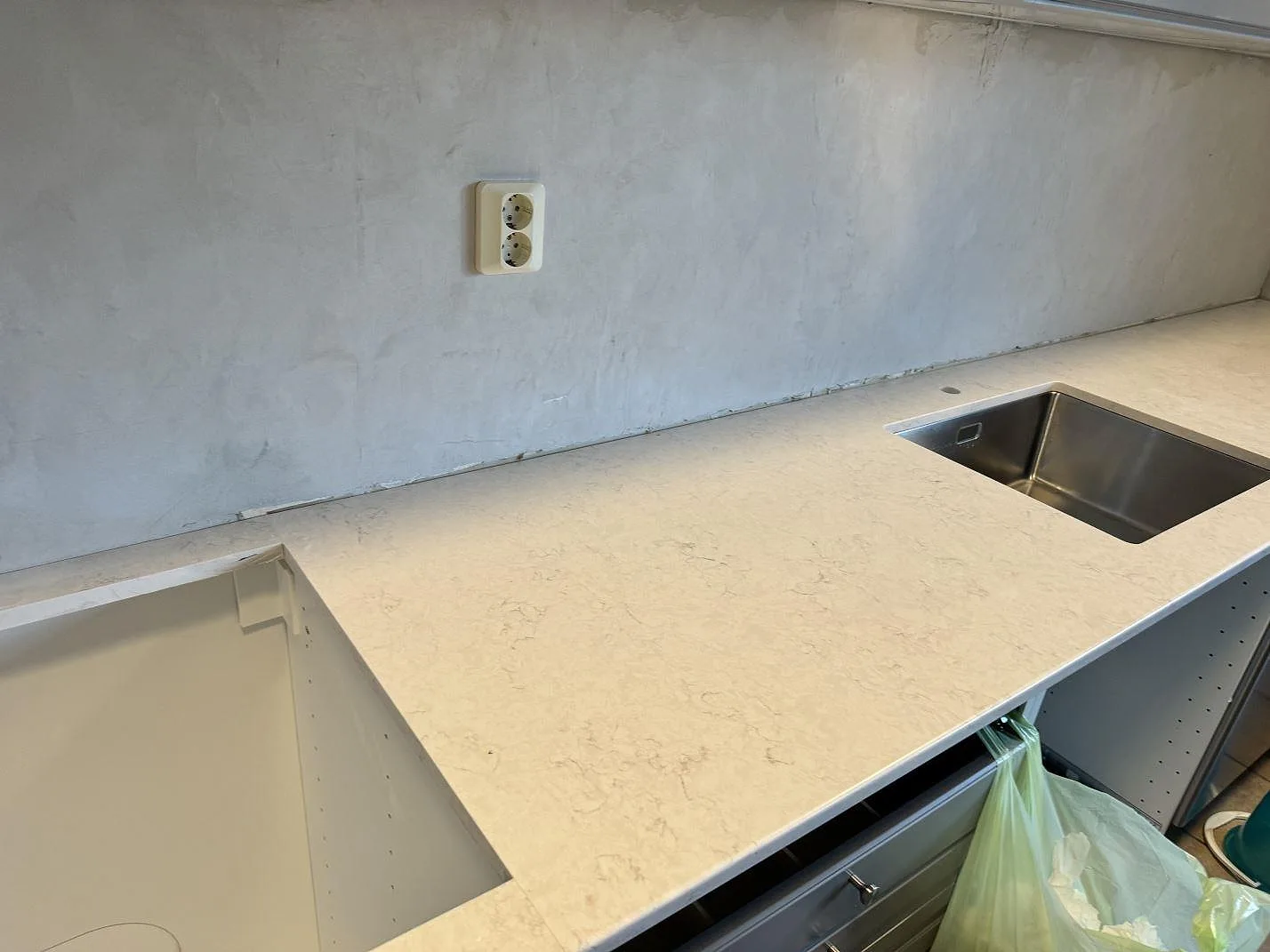 Køkkenbordplade i poleret Silestone Snowy Ibiza kvartskomposit med lys marmorering, rostfri vask og öppet köksstomparti i Svedala.