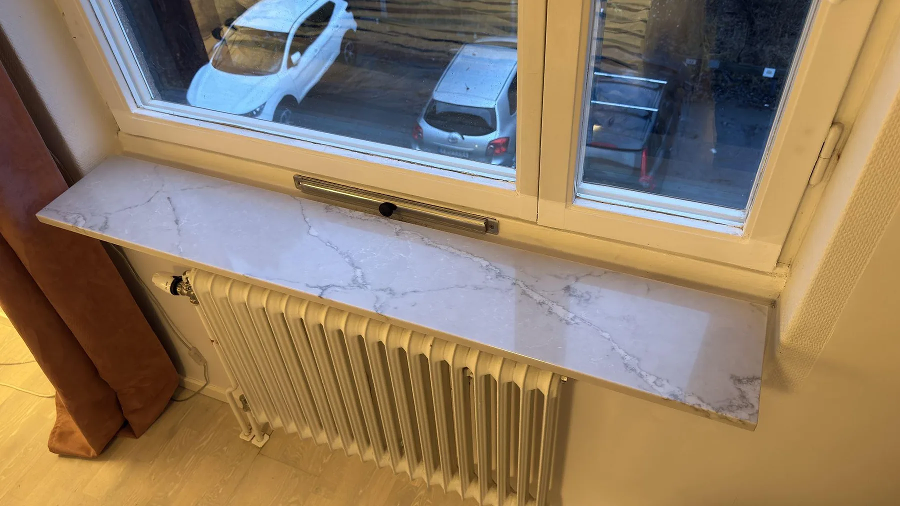 Poleret vindueskarm i 20 mm Silestone Victorian silver med grå åretegning over ett element i Bromma.