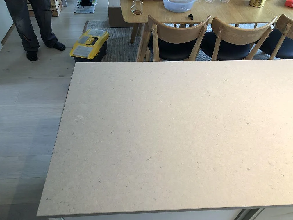Poleret kompositbänkskiva i Technistone Crystal Absolute White på kökshalvö med matplats i bakgrunden i Skanör.