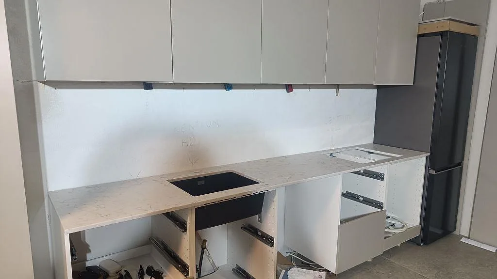 Køkkenbordplade i Technistone Mystery White, poleret kvartskomposit i 20 mm, monteret längs en lige köksrad i Malmö.
