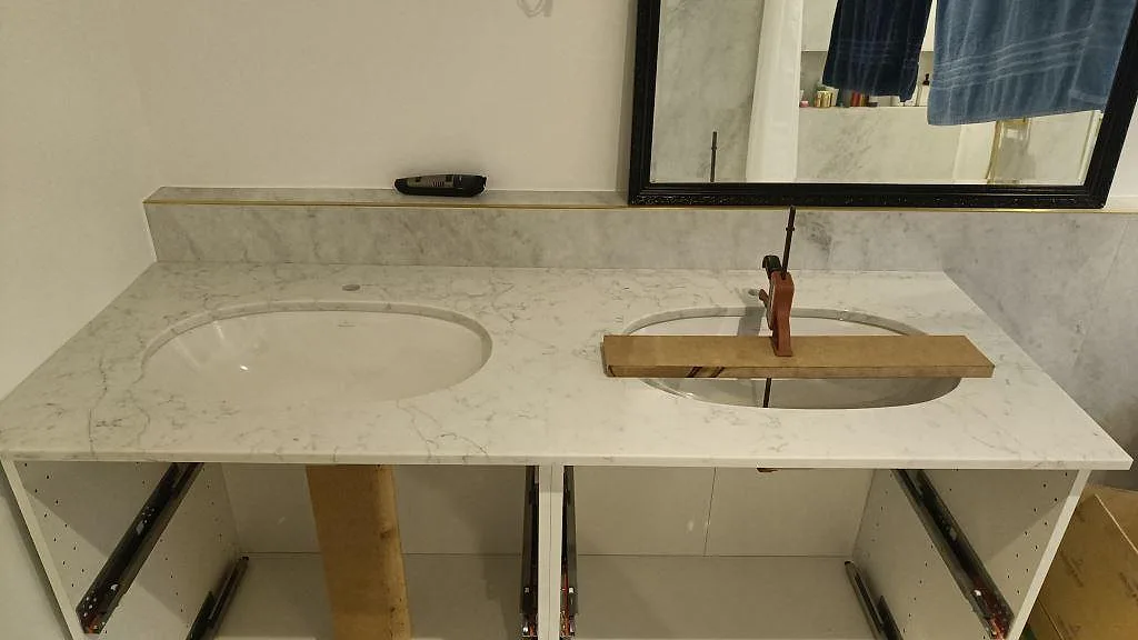 Badrumsbänkskiva i poleret Technistone Mystery White komposit med två ovala tvättställ og stänkkant i Råå.