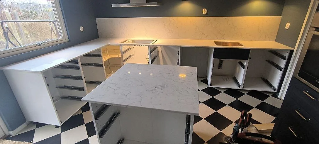 Køkkenbordplade i hvid Technistone Mystery White, poleret komposit, med køkkenø og stænkplade i ett køkken i Täby.