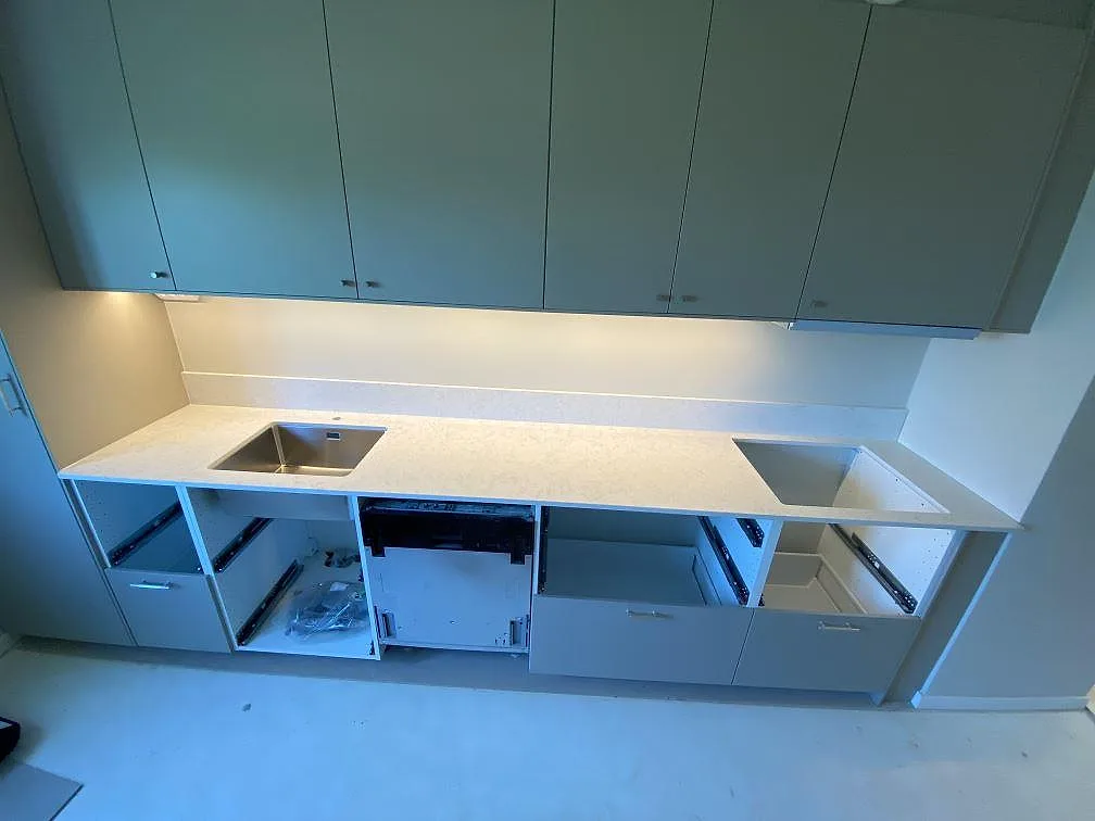 Køkkenbordplade i Technistone Noble Arco, poleret kvartskomposit, med låg stänkkant, vask og förberett rektangulärt udskæring i ett køkken i Malmö.