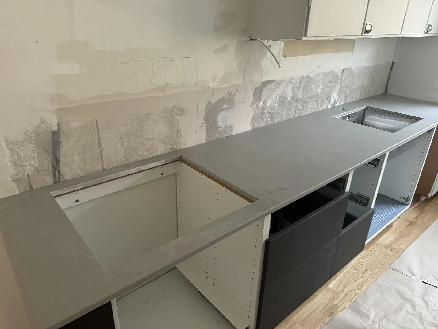 Køkkenbordplade i Technistone Noble Concrete Grey, mat kvartskomposit, monteret på köksstommar med vask og stort udskæring i Göteborg.