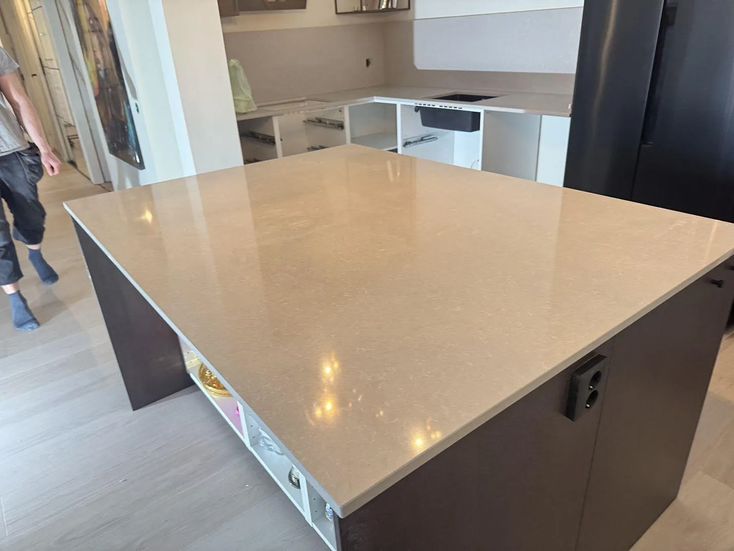Poleret køkkenbordplade i Technistone Noble Ivory White, 20 mm komposit, med stor køkkenø, sort vask og stænkplade i ett køkken i Kungsbacka.