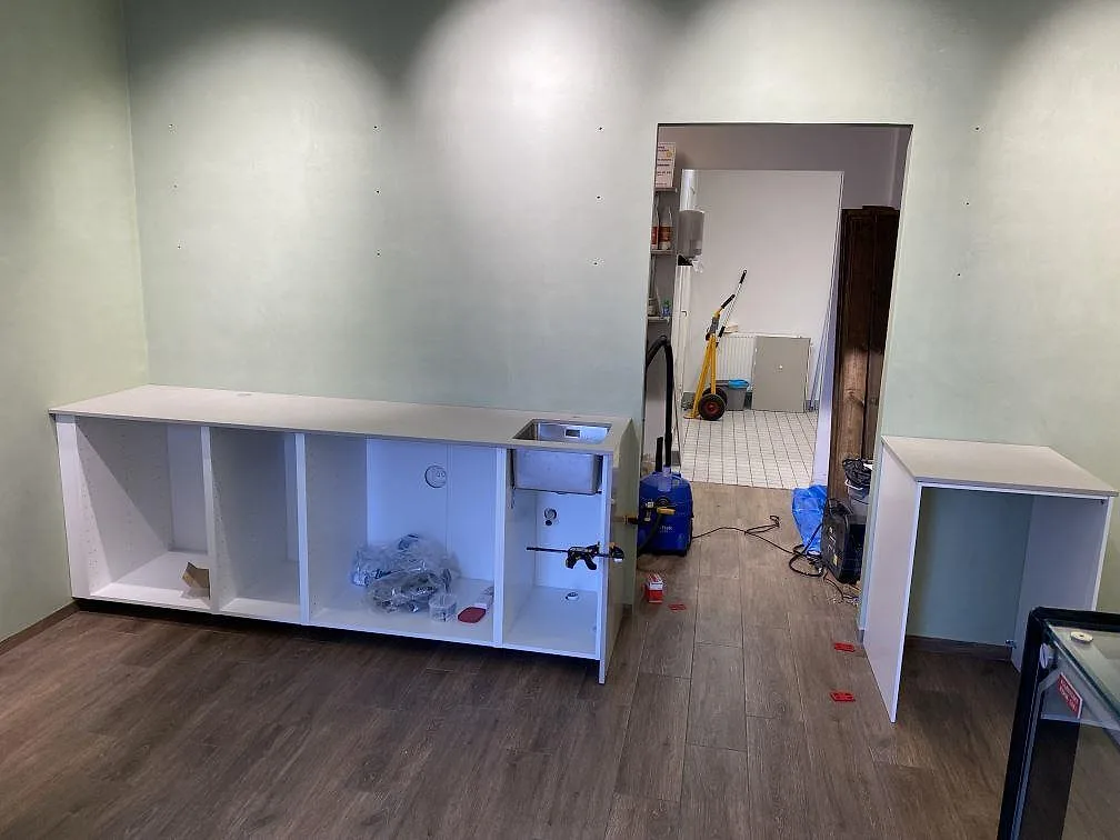 Køkkenbordplade i Technistone Noble Ivory White, poleret kvartskomposit, med underlimmad rostfri vask i ett køkken under montering i Lomma.