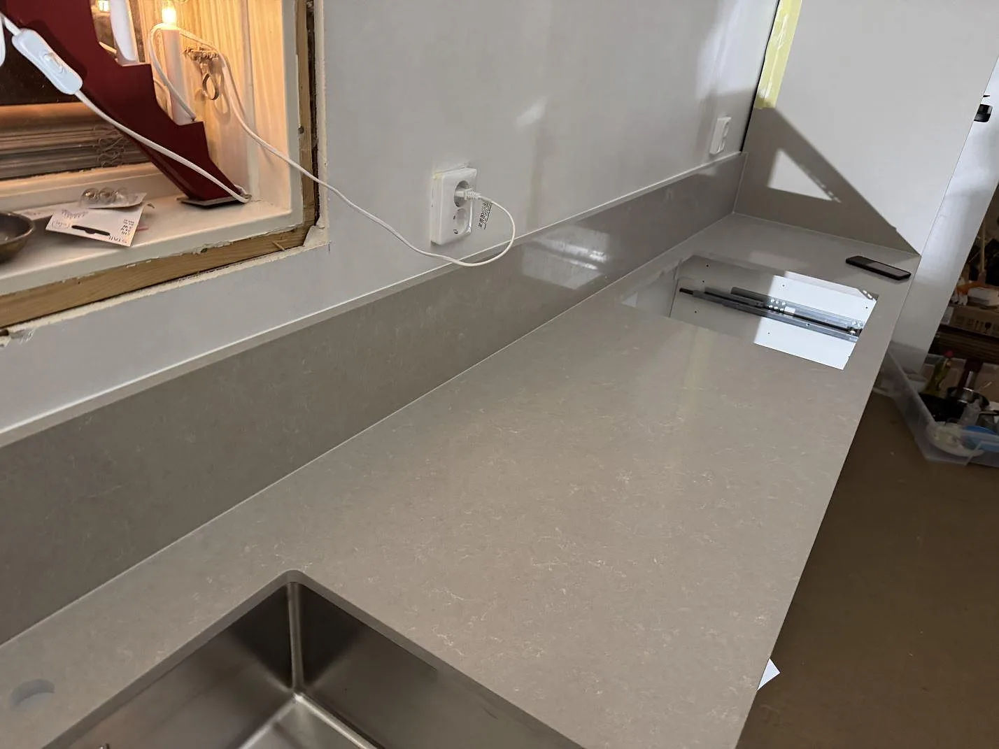 Køkkenbordplade i poleret Technistone Noble Ivory White med uppvikt stänkkant, rostfri vask og hällöppning i Ronneby.