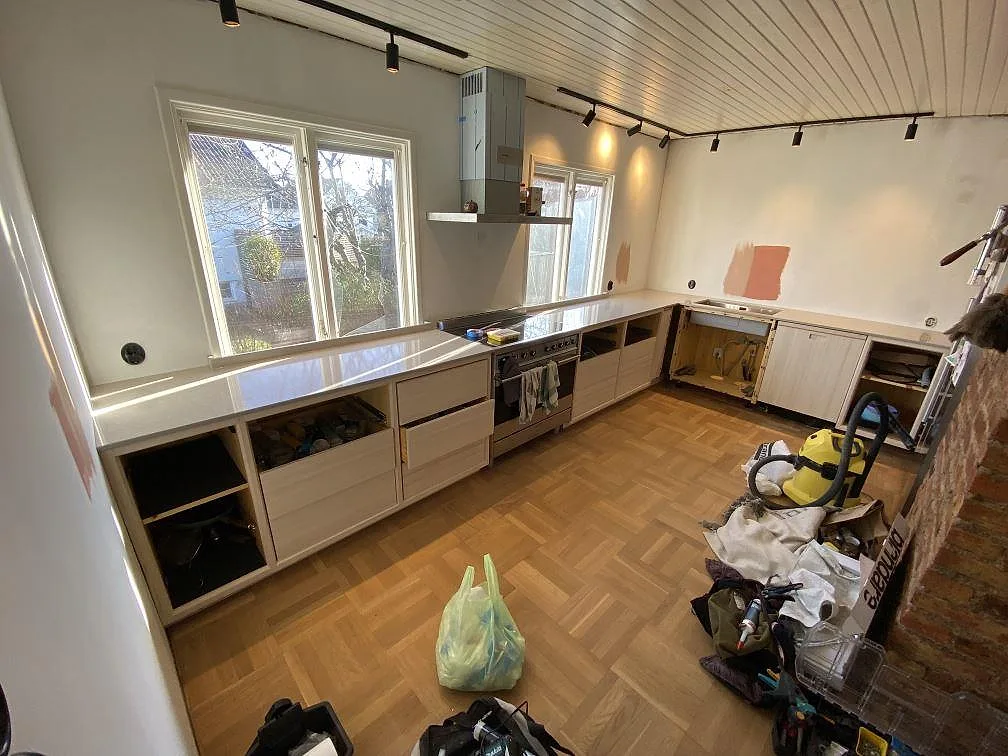 Översiktsbild af køkken i Västra Frölunda med poleret køkkenbordplade i Technistone Noble Ivory White og monteringsarbete kvar.