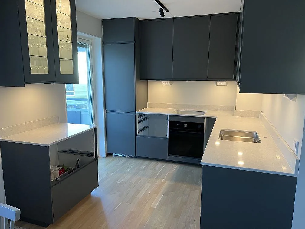 Køkkenbordplade i Technistone Noble Quartzite, poleret kvartskomposit, med lyse bänkytor og rostfri vask i ett køkken i Gustavsberg.