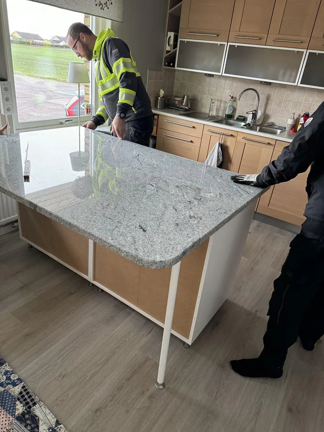 Köksöskiva i poleret Viscont White granit, 30 mm, under montering i ett køkken i Vallåkra.